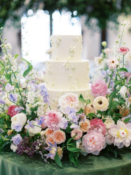 Wedding cake adorned with flowers.