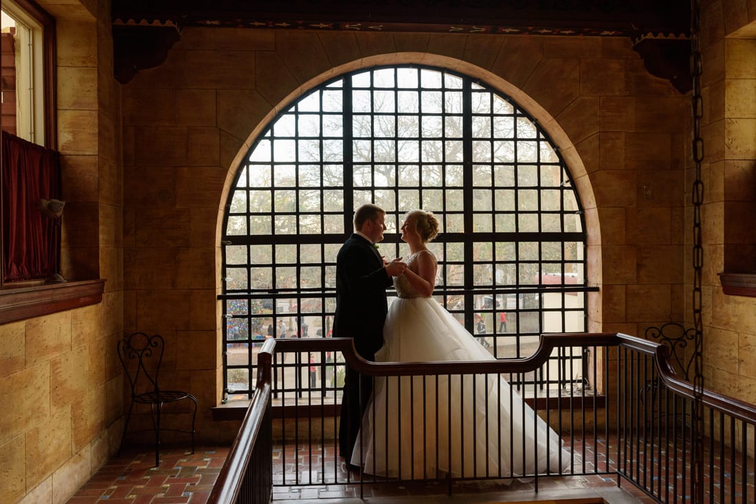 Bride and groom first look in front of beautiful window at The Treasury on the Plaza