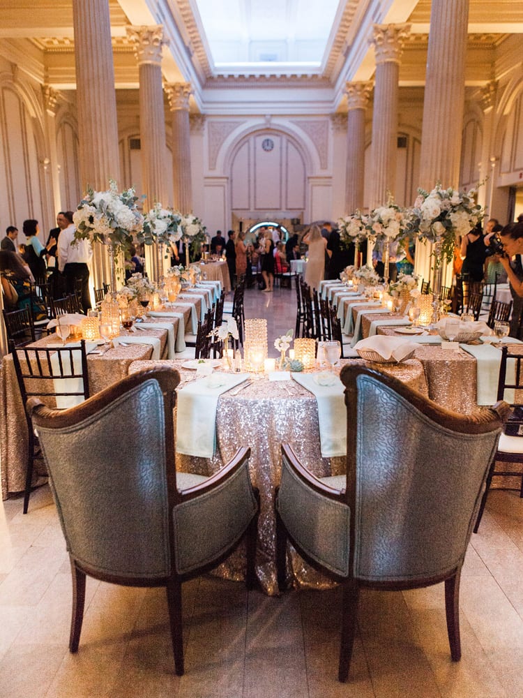 Sweetheart and king’s table are placed in the center of the ballroom for the wedding reception in the same room.