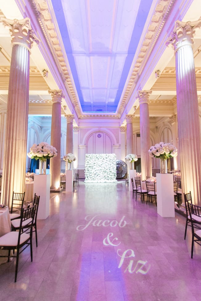 The names of the happy couple are projected onto the dance floor of the reception, previously the aisle during the wedding ceremony.