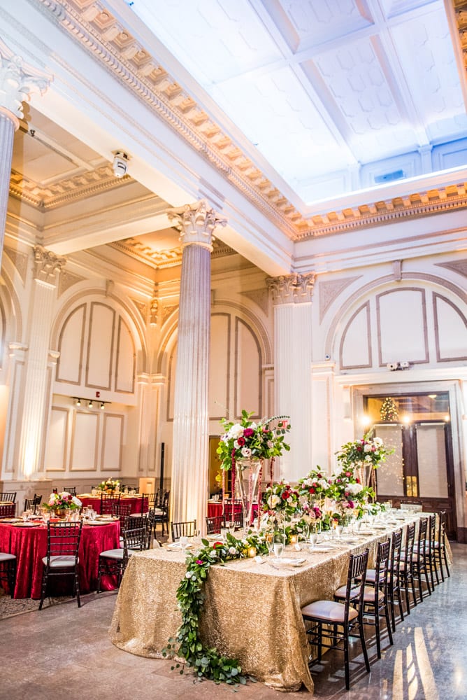 King’s table for the wedding reception uses the floral arrangements that decorated the altar during the ceremony held in the same room.