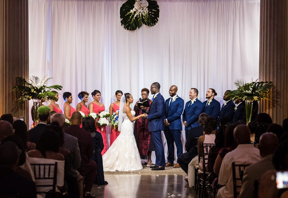 Large palm leaves and bright colors accent this Florida-themed wedding ceremony.