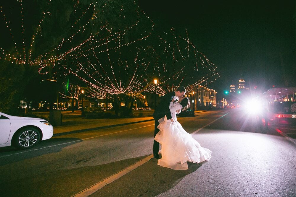 bride and groom kiss in the street during Nights of Lights in St. Augustine