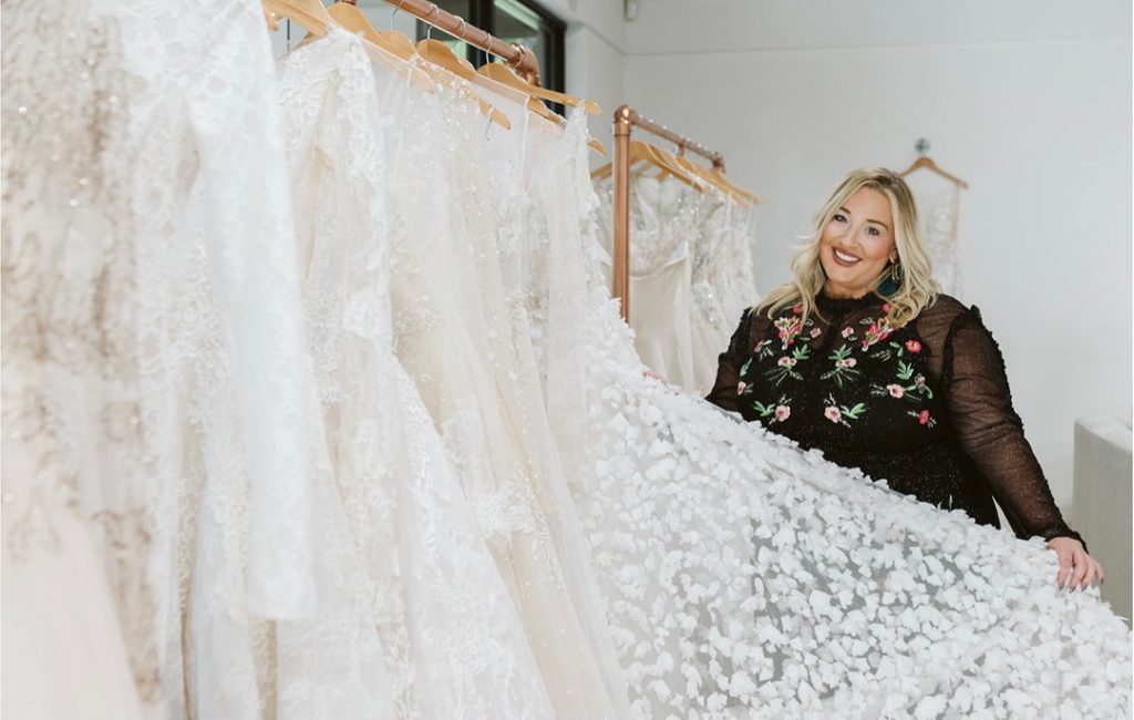 bridal salon consultant holding out wedding dress train