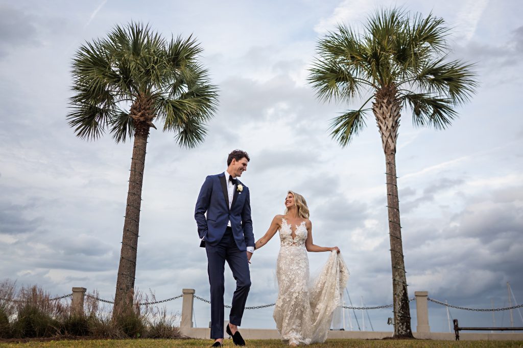 bride and groom walking outside flanked by palm trees