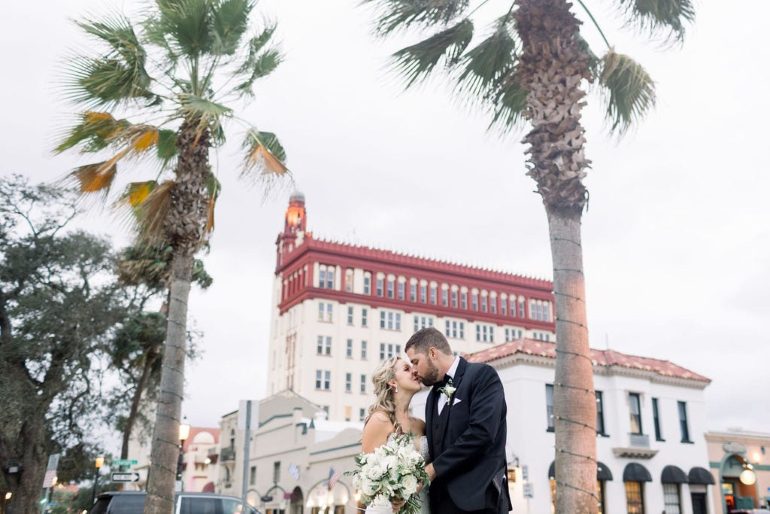 A bride and groom kiss after their wedding ceremony in front of The Treasury on the Plaza in St. Augustine