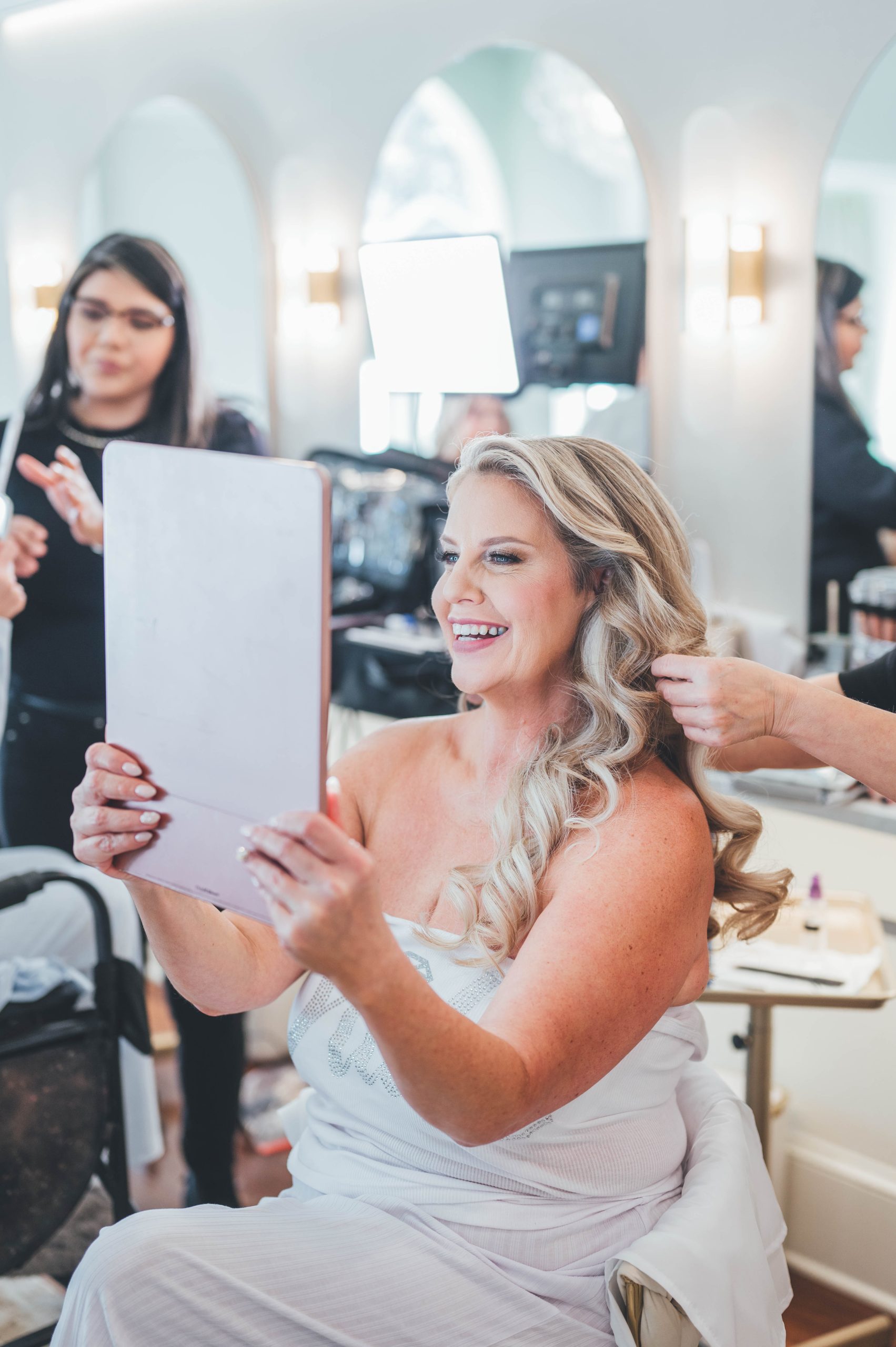 Bride Heather looking at her finished hair and makeup