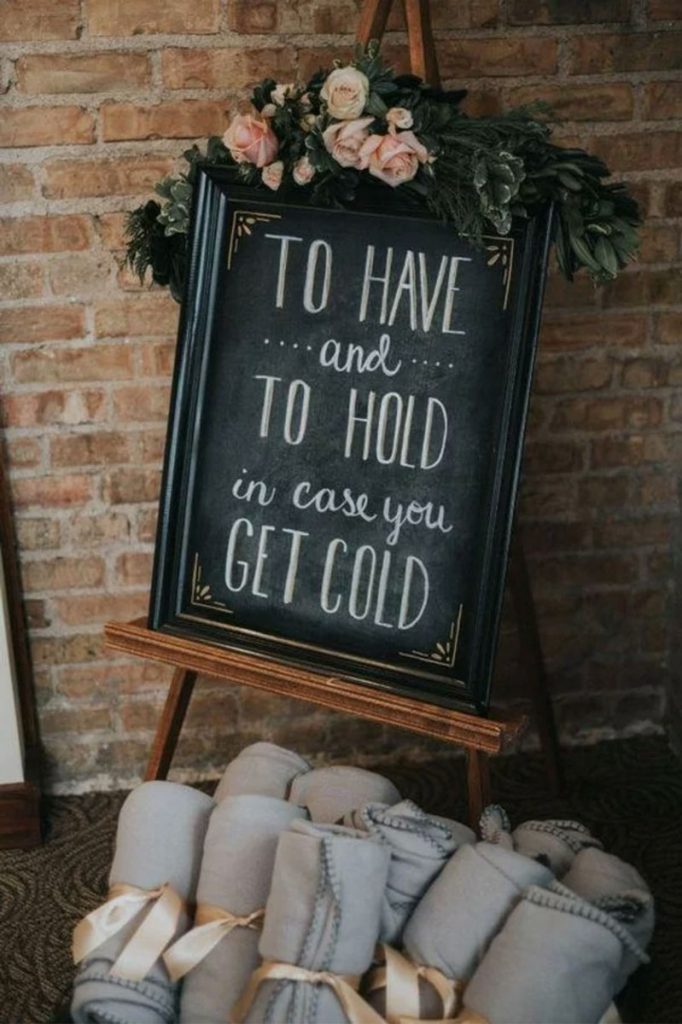 sign reading To Have And To Hold In Case You Get Cold next to warm blankets as wedding favors