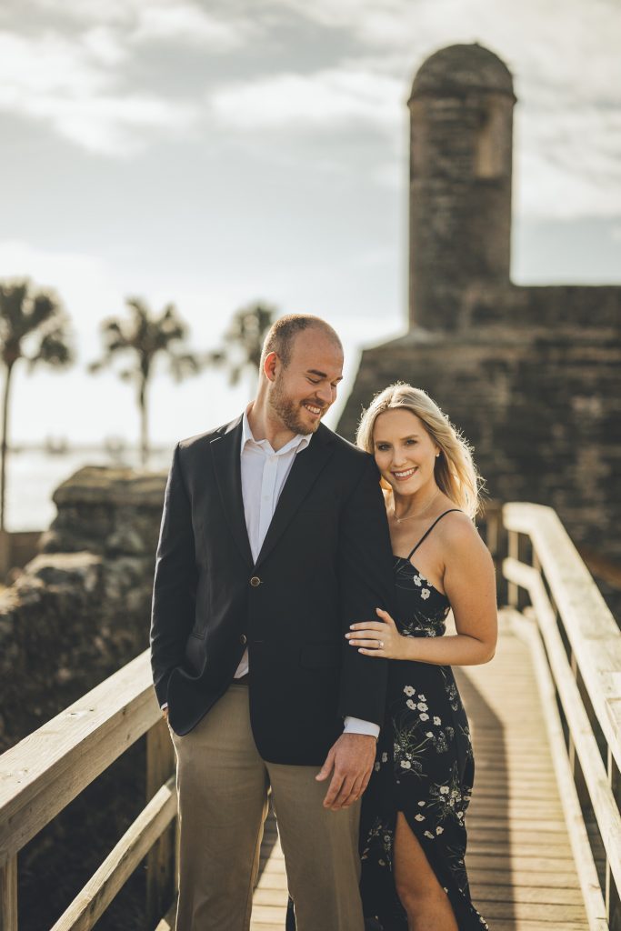 engaged couple on a bridge with St. Augustine fort in the background