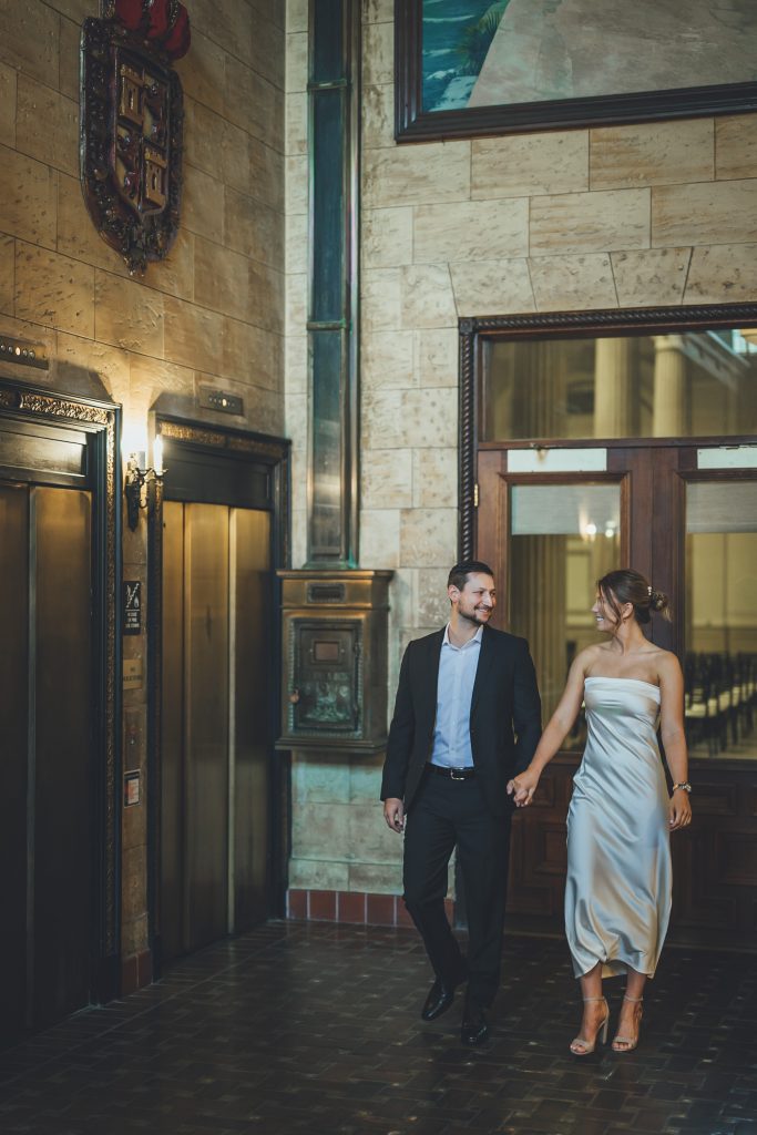 engaged couple inside historic bank in St. Augustine taking engagement photos