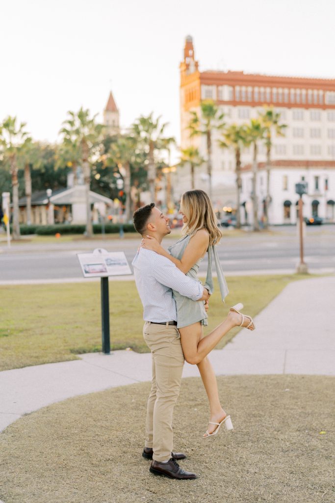 engagement photo of man lifting his fiancee in downtown St. Augustine