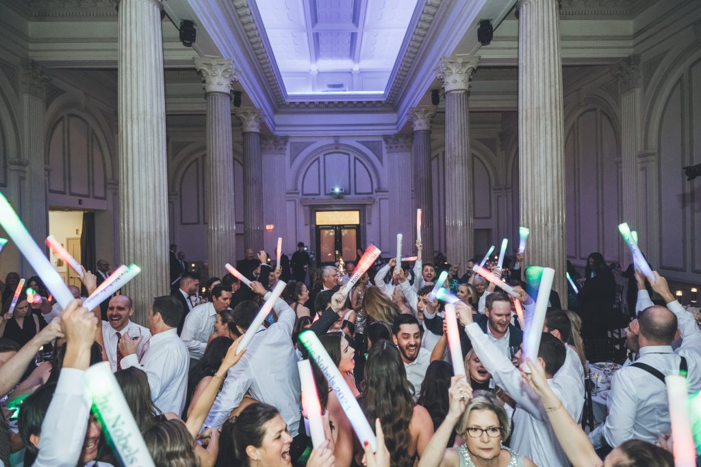 Dance floor packed with guests holding light sticks at Adelaina and Oliver's wedding