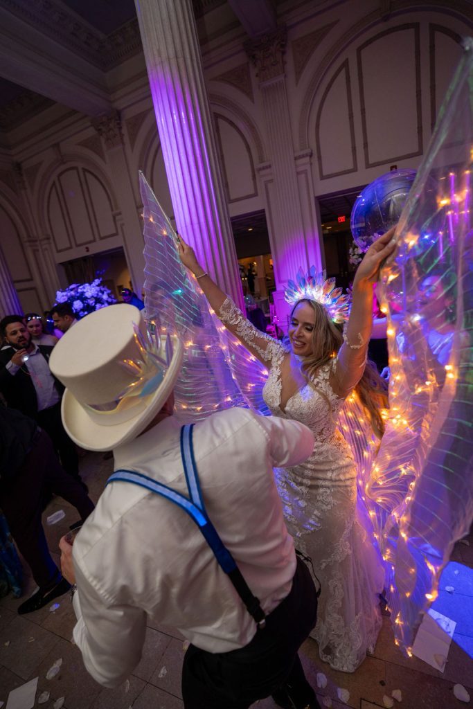 Bride wearing light up wings on the dance floor