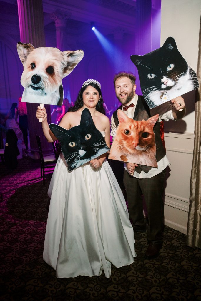 bride and groom with giant cutouts of their pets