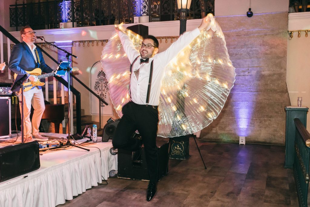 man on wedding dance floor with light up wings