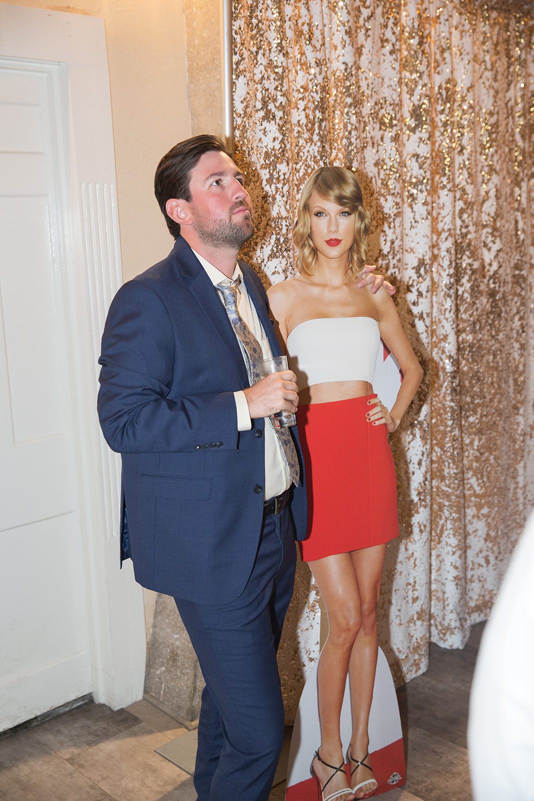 Man posing with cardboard cutout of Taylor Swift