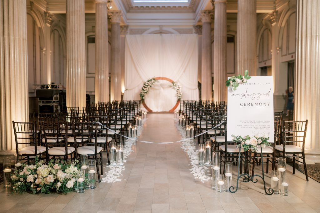 Flowers line the aisle and backdrop of a wedding ceremony