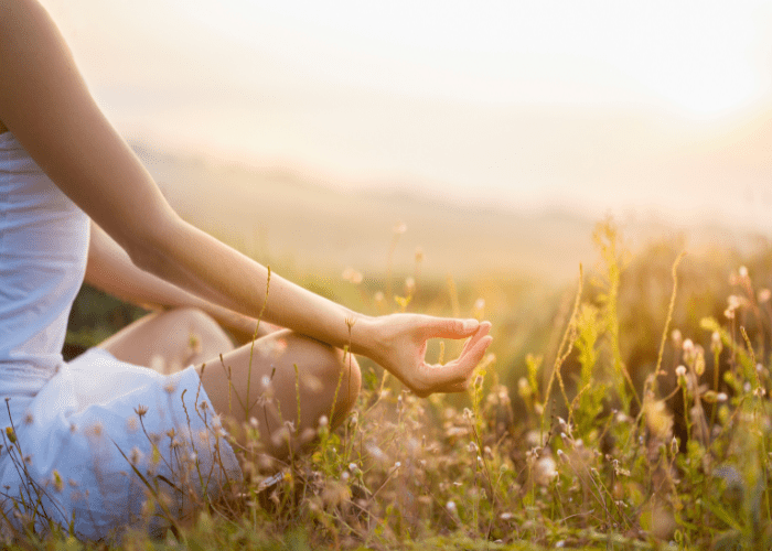 woman meditating in field