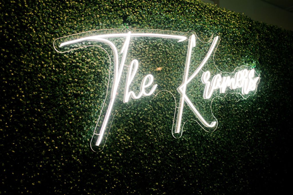 Vine wall with neon sign reading "The Kramers"