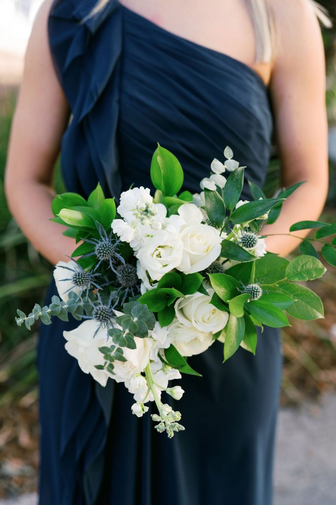 closeup of bouquet held by bridesmaid in navy dress
