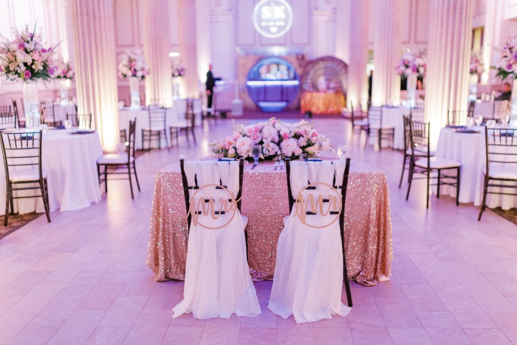 sweetheart table with Mr. and Mrs. signs on the back of the chairs