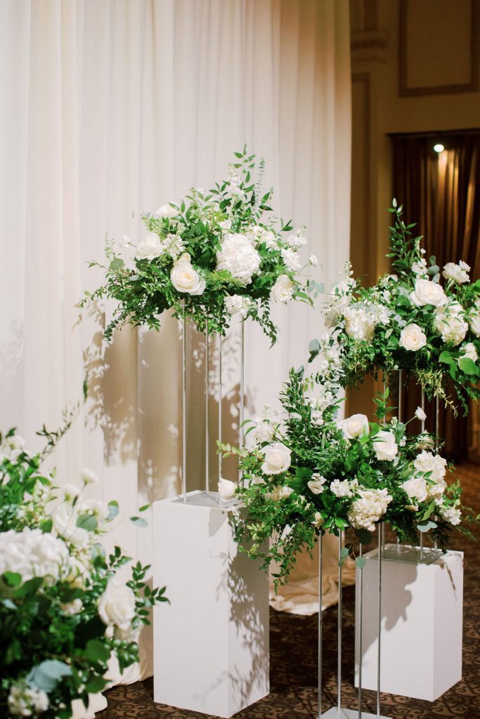 floral arrangements on clear pedestals