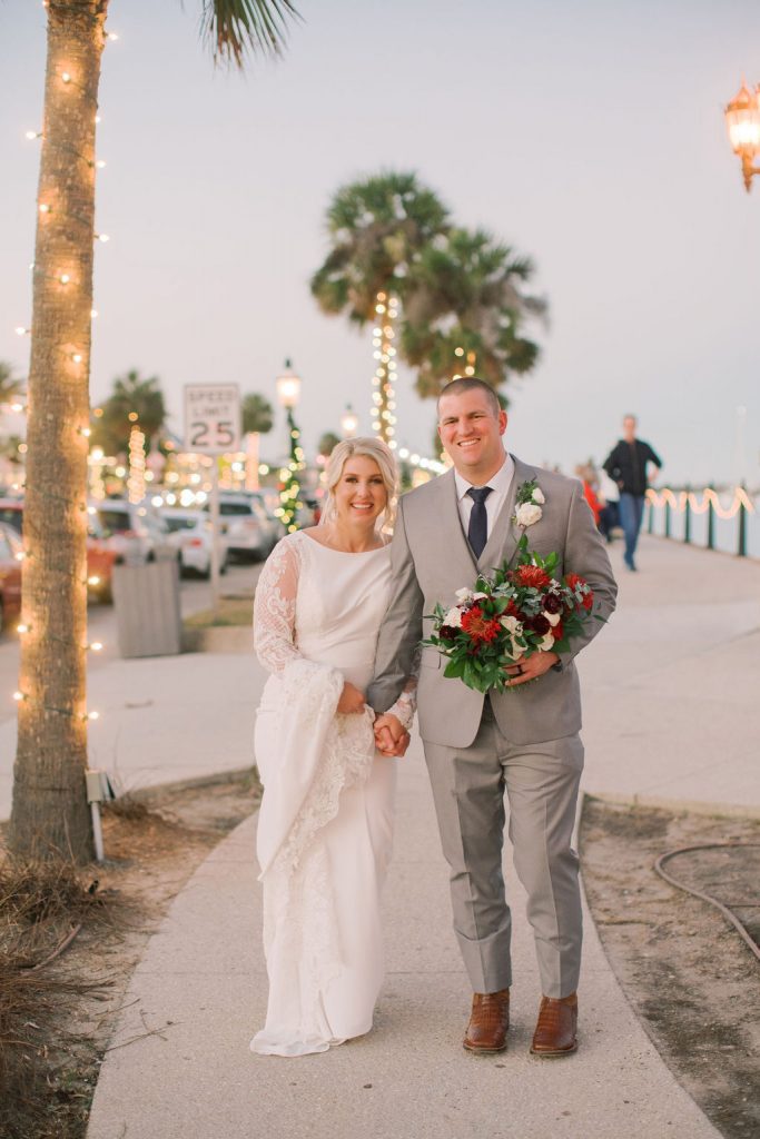 bride and groom at marina lit with christmas lights