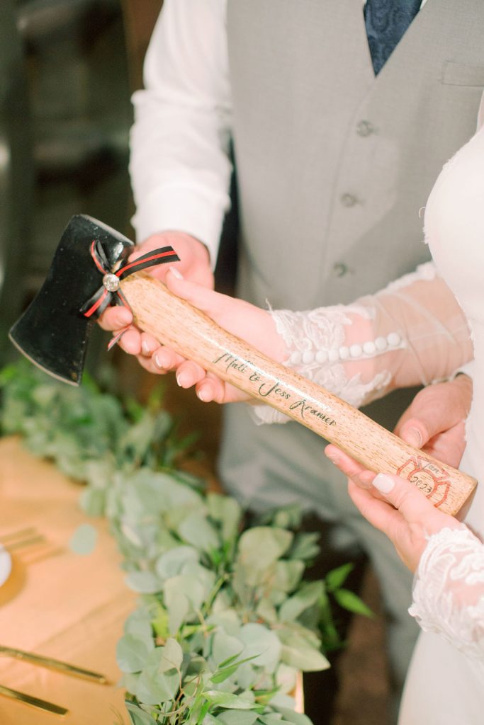 Bride and groom with a personalized fireman's hatchet