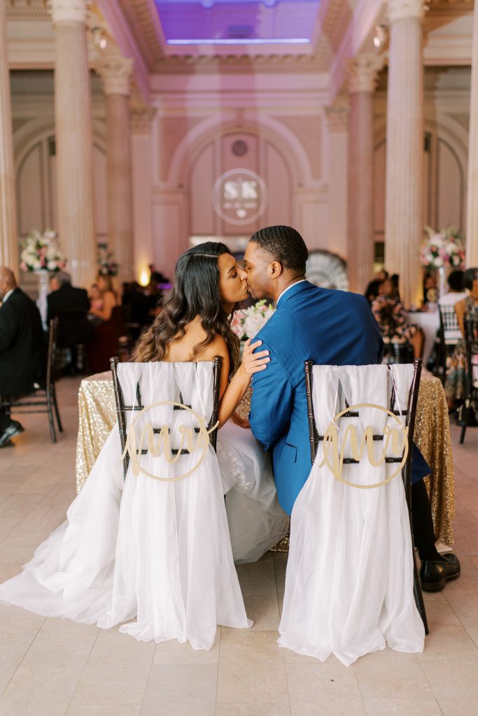 Kevin and Sarah kissing at the sweetheart table