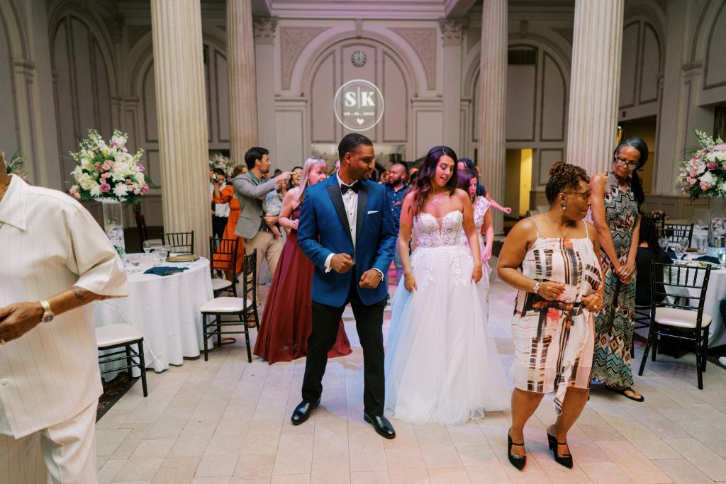 bride and groom dancing with guests at their wedding