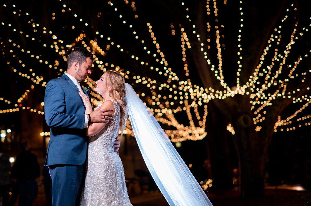 Bride and groom take photos in the plaza in St. Augustine during Nights of Lights 