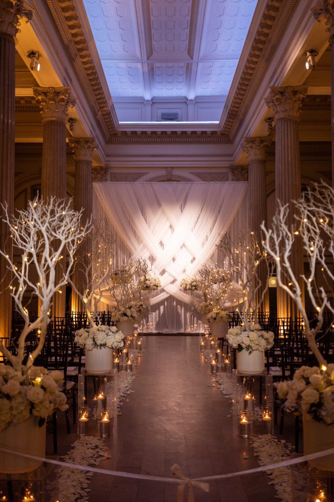wedding aisle with white drapery and white branches 