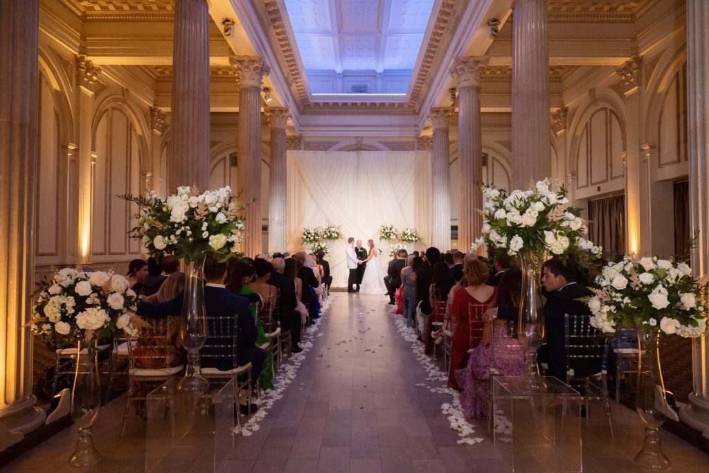 Large floral decorations at the end of wedding ceremony aisle