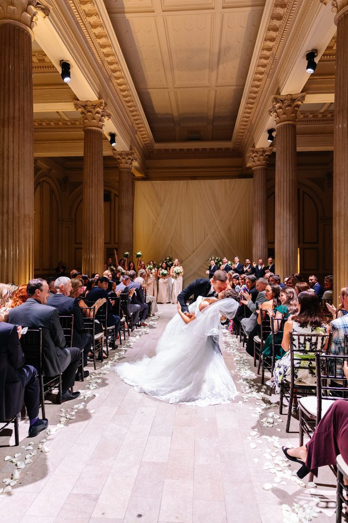 Groom dipping bride for a kiss after ceremony