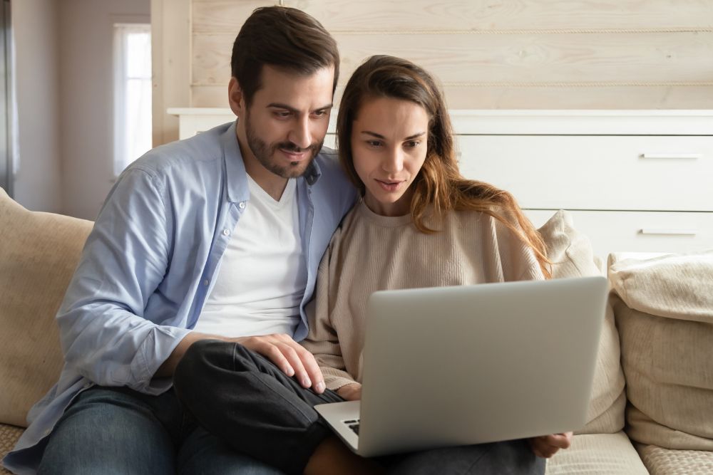 couple looking at website while sitting on couch