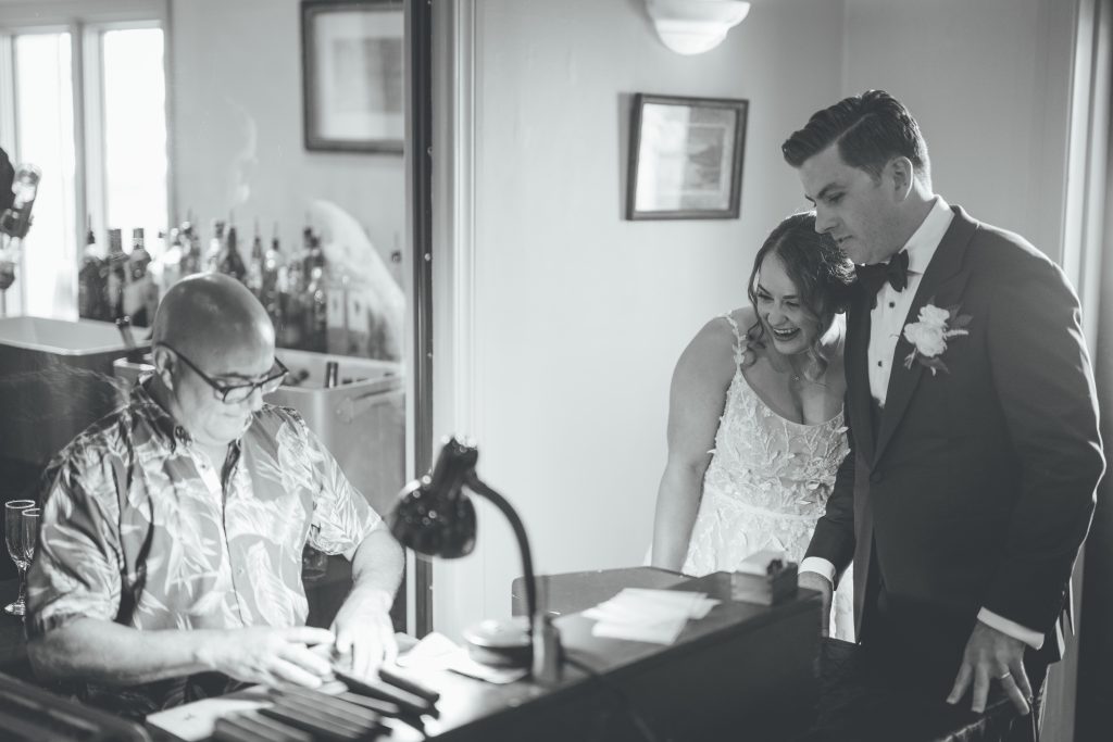 black and white photo of bride and groom watching Cuban cigar roller