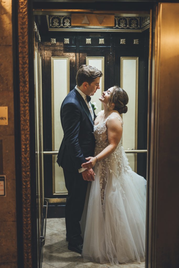 Bride and groom inside antique elevator at the Treasury on the Plaza