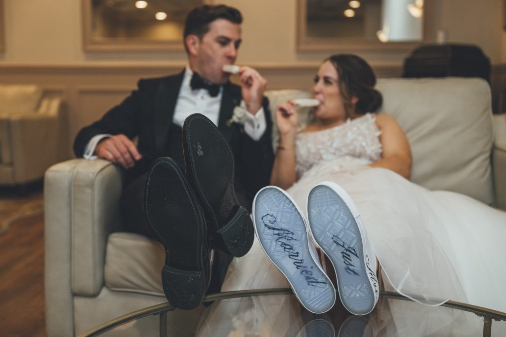 bride and groom sitting on couch eating popsicles