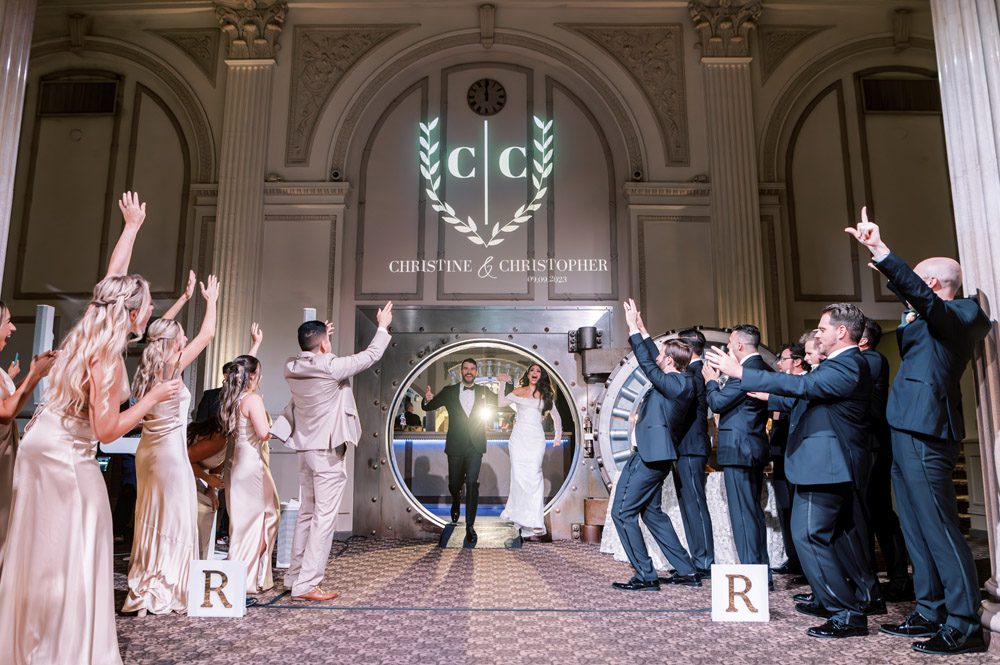 Bride and groom enter wedding reception through bank vault at The Treasury on the Plaza
