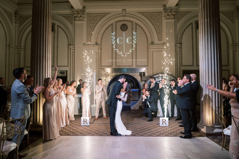 Bride and groom enter wedding reception through bank vault at The Treasury on the Plaza
