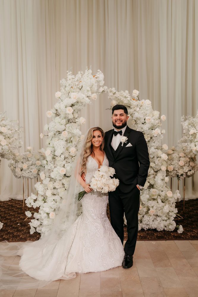 Couple in front of Ceremony Backdrop