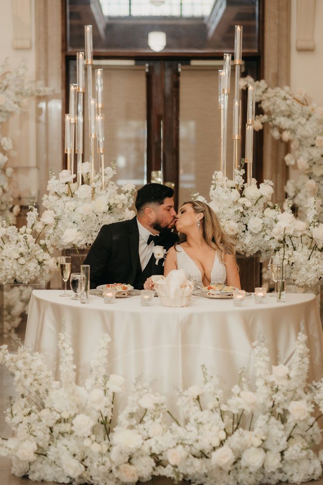 Couple At Stunning White Floral Sweetheart Table
