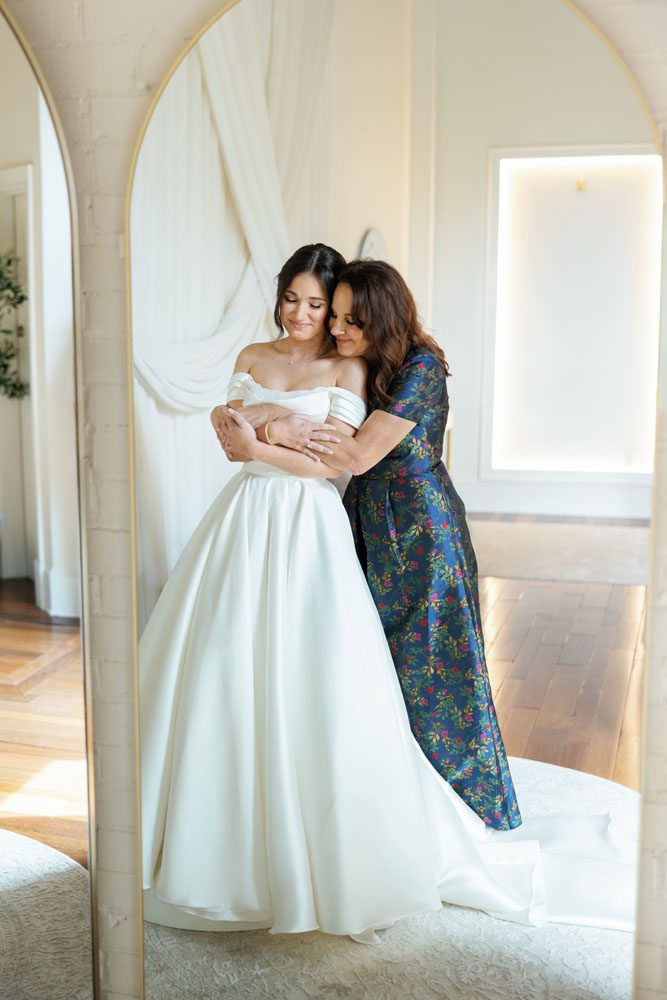 Mom hugging her daughter on her wedding day